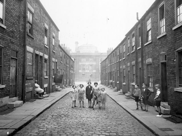 Children, one with a bicycle, pose in the centre of Imperial Street. Joseph Hobsons Dantzic Brewery has been built on the site of East Imperial Street. Two storey brick houses with cellars, in state of dilapidation.