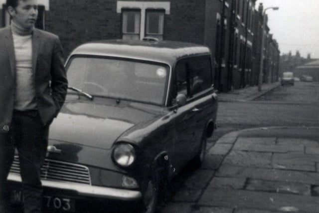 A view looking from Colenso Grove, where a man stands in front of a Ford Anglia van parked outside no. 1, past Cleveleys Avenue towards Recreation Place. Pictured in August 1967.
