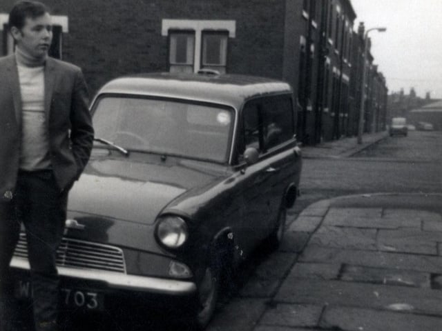 A view looking from Colenso Grove, where a man stands in front of a Ford Anglia van parked outside no. 1, past Cleveleys Avenue towards Recreation Place. Pictured in August 1967.