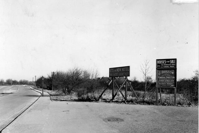 A view looking north along Harrogate Road from the Sandhill estate area. Signs on wooden supports are for "Site for new hotel - John Smith's Magnet Ales", "Houses for sale" and "J. Bristow funeral director/joiner/property repairs".