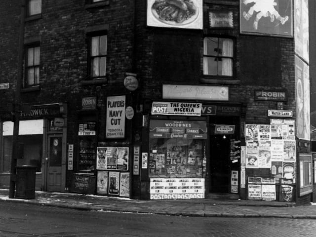 L E Cantral newsagents, and E Chadwick cycle shop on Victoria Road in February 1956. Tram lines are visible in cobbled road. Many advertising boards for various products including Walls sausages, Persil soap powder, Woodbines, Players navy cut cigarettes, Standard fireworks, Hornimans tea and the Evening Post.