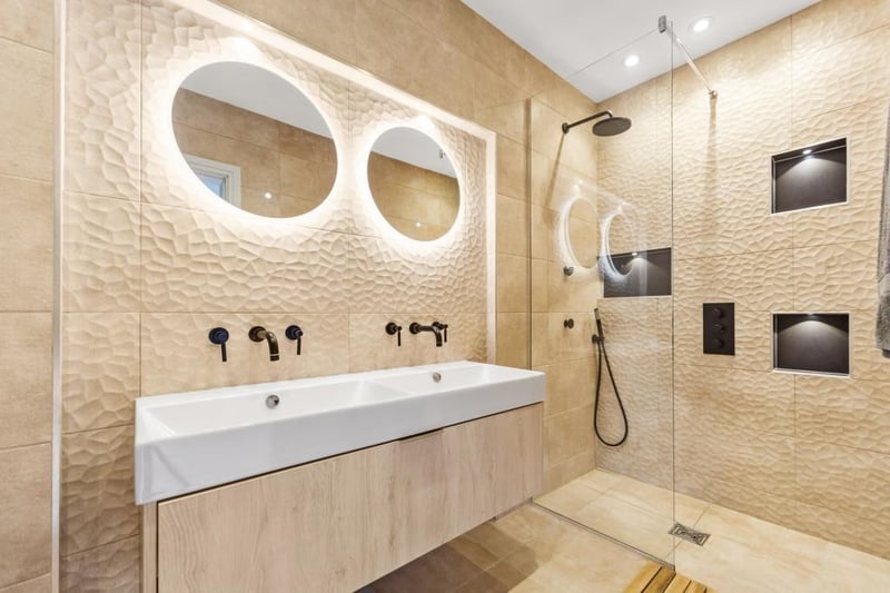 A double wash basin unit and a walk-in shower in this stylish facility.