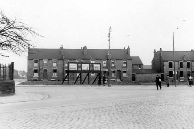 Stanningley Road as it runs past the end of Lower Town Street in March 1939. To the left can be seen part of wall and railing which enclose the school yard of Bramley National School.