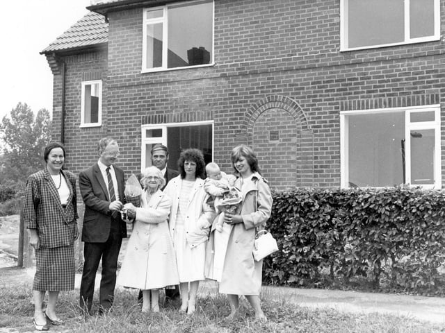 Councillor George Mudie as he presents keys to new tenants of Brander Mount. This was the conversion of 12 'cottage' style flats to 6 2-bedroomed semi-detached homes, carried out under the Priority Estates Programme and the Community Refurbishment Scheme. It was part of a long-term plan by Leeds City Council to improve the standard of older housing estates in the city. The houses were equipped with new bathrooms, central heating, new roofing, re-wiring and new doors and windows at a cost of £20,000 each. The new tenants pictured are Geoff, and Brenda Bull with Mrs. Bull's mother, Mrs. Lizzie Speight and Jane Green with her nine month old daughter, Rachel.