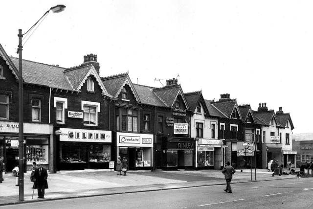 A parade of shops on Roundhay Road numbered (from left) 275 to 291. These include John Gilpin Ltd., bakers and confectioners, at no.277 with Margaret McDonald, coiffeur, above. Next right is Crockatt's cleaning followed by Ainley (Leeds) Ltd., electrical engineers and Doreen, ladies' fashions. At the end of the parade, by the junction with Harehills Lane (known as Harehills Corner) is the Leeds and Holbeck Building Society at no.291. Across the road at no.293 is the Yorkshire Penny Bank. Pictured in June 1966.