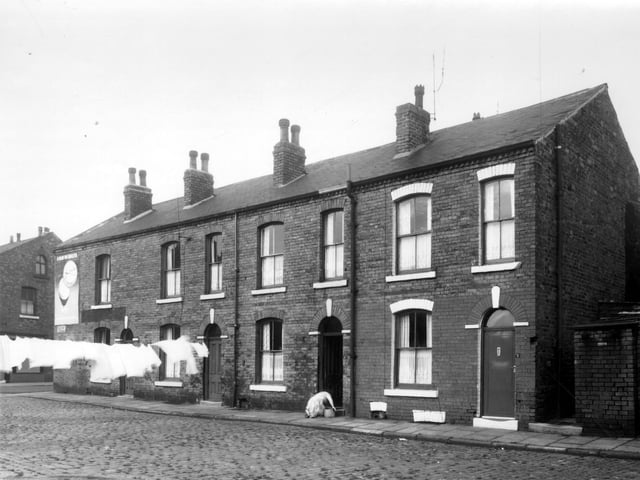 Sackville Street is on the left, then number 1 Belfort Terrace is partly obscured by washing. Moving right, 3 then 5, where a woman is kneeling to wash the steps. Pictured in October 1960.