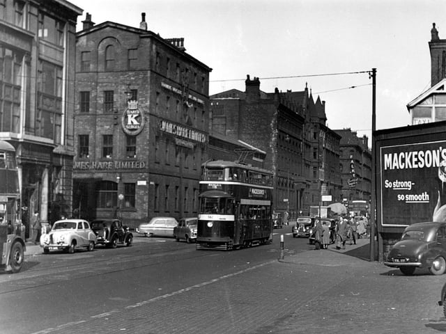 A view of tram 562 travelling along Wellington Street on route 15 to Whingate in June 1955. Various businesses are visible including James Hare Ltd the woollen merchants at 72 Wellington Street.