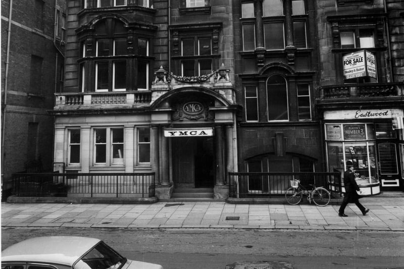 Albion Place in April 1983 showing the YMCA building in the centre. This opened in 1908 and was used for the YMCA until 1984. To the right a policeman is seen walking past Eastwood tobacconists. On the left an alleyway known as Change Alley runs between the YMCA and the County Court building.