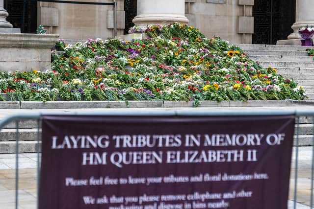 Florial tributes in memory of HM Queen Elizabeth II on the steps of Leeds Civic Hall and inside a book of condolence for members of the public to sign.