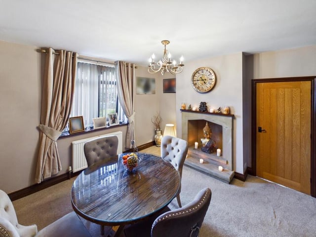 The formal dining room has a feature fire place with hearth and surround, is carpeted throughout, and has a central heated radiator.