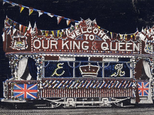 Tinted postcard showing a side view of the specially commissioned illuminated electric tram for the royal visit to Leeds of King Edward VII and Queen Alexandra on July 7, 1908. The illuminated tram visited all areas of the city in the week that followed the visit. 3,000 electrical lights provided the decoration and lettering. It reads 'Welcome to our King and Queen'. The royal couple were in Leeds to open the new electrical engineering building of Leeds University.