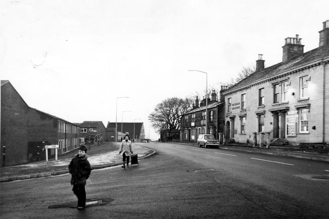 A boy and women cross Bell Lane in May 1979. On the right is Upper Town Street with Beecrofts Land and Estate Agent Auctioneers & Valuers on the far right of the image.