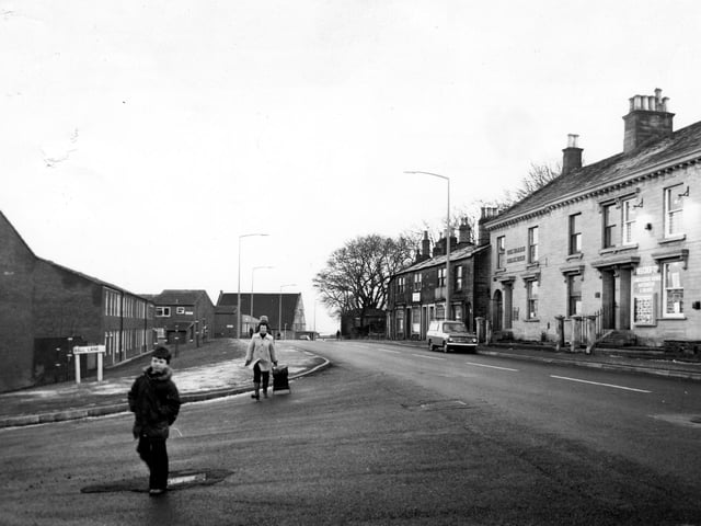 A boy and women cross Bell Lane in May 1979. On the right is Upper Town Street with Beecrofts Land and Estate Agent Auctioneers & Valuers on the far right of the image.