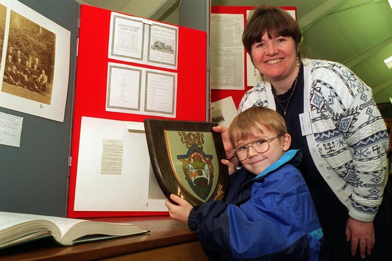 Librarian Janet Bennett shows young Ben Holdsworth the old Rothwell District Council emblem at a Centenary Display in March 1996.