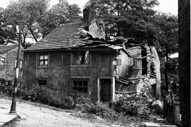 Cottages on Tower Lane in Upper Armley pictured in July 1950. Number 68 is badly damaged. There is a lamp post in view.