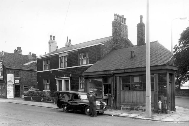 Armley Town Street in July 1960. On the left edge of this view a pet food and garden stores can be seen. Moving right are two through house followed by a butchers, the business of E. Kaye and then the business premises of J. Haigh.