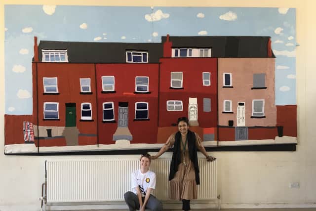 The huge Baywater Tapestry is welcomed to Woodhouse Community Centre by Lily and Minnie.
