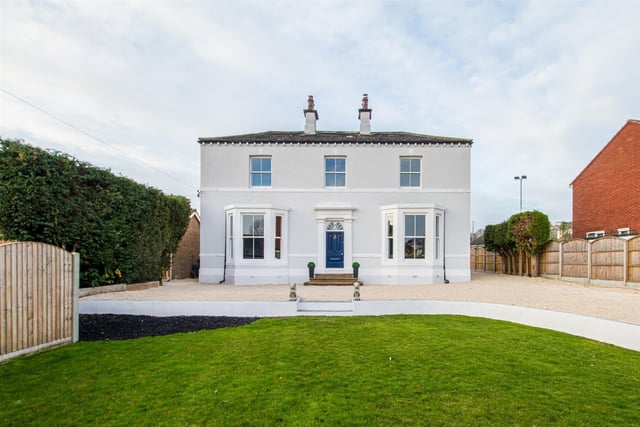 The impressive period property has a stone pebbled driveway with lawned garden to the front.