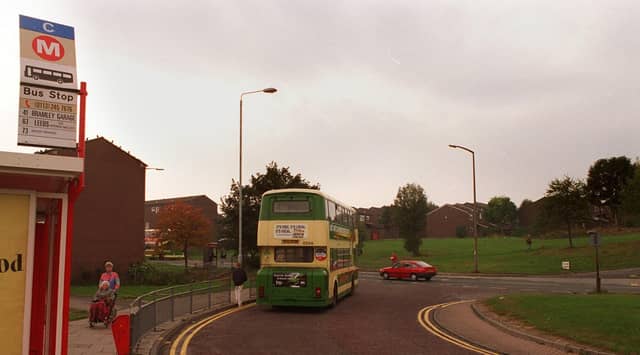A bus standing at Bramley Shopping Centre bus terminal with the Rossefield estate in the background in October 1997.