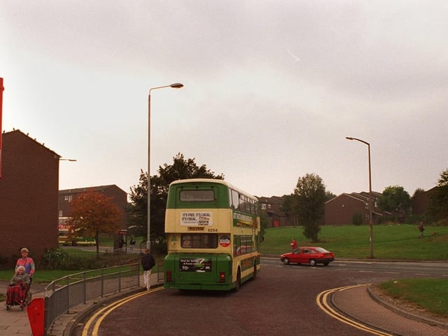 A bus standing at Bramley Shopping Centre bus terminal with the Rossefield estate in the background in October 1997.