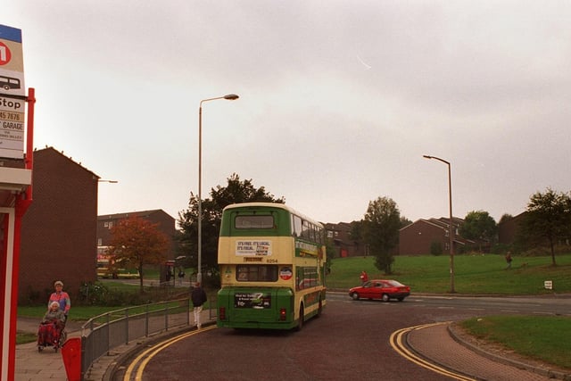 A bus standing at Bramley Shopping Centre bus terminal with the Rossefield estate in the background in October 1997.
