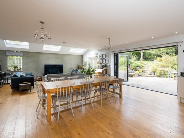 From this living kitchen hub, bi-fold doors open to a sizeable terrace, perfect for entertaining, with the rear garden beyond.