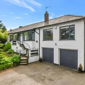 Accessed through wrought iron double gates, the property provides off-street parking for multiple cars.