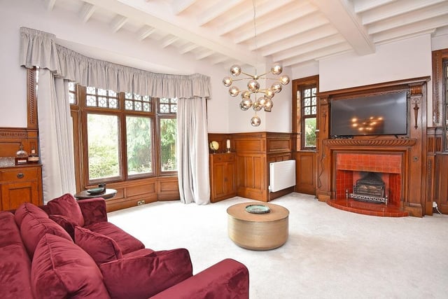 The large fireplace is a feature within this reception room with bay window.