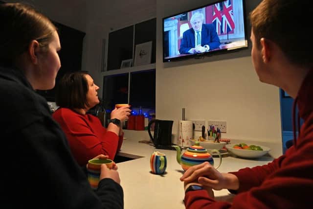 A family gather around the television to watch Boris Johnson give a televised message to the nation from 10 Downing Street in London, on January 4 2021 (Photo: PAUL ELLIS/AFP via Getty Images)