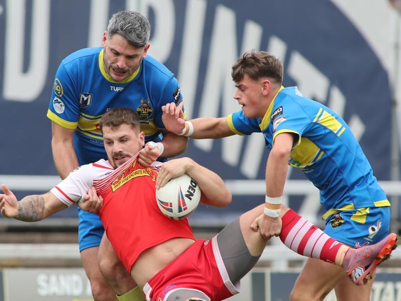 East Leeds full-back Luke Littlewood, who was named man of the match, is tackled by Oulton Raiders' Adrian Holdsworth, left.