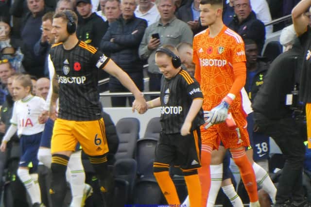 Leeds United skipper Liam Cooper leads the team out at the Tottenham Hotspur Stadium alongside mascot Herbie Hawker (Pic: Heidi Haigh)