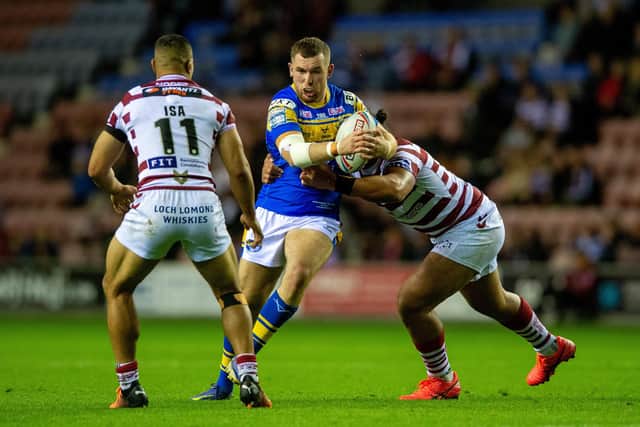 Cameron Smith is tackled by Wigan's Patrick Mago in the semi-final last week. Picture by Bruce Rollinson.