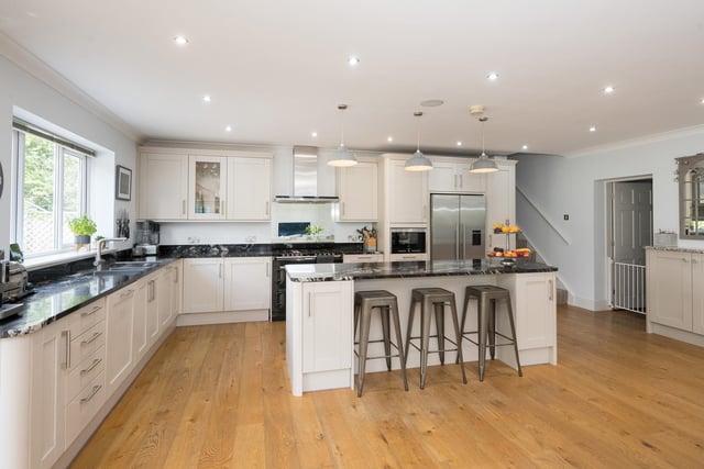 At the heart of the home is a large, open plan living kitchen with fitted units, and a central island with breakfast bar.