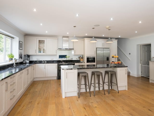 At the heart of the home is a large, open plan living kitchen with fitted units, and a central island with breakfast bar.