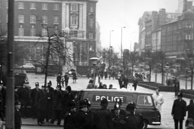 Policemen in uniform, assembled near the Garden of Rest and War Memorial on The Headrow. A police van is also parked in Calverley Street.