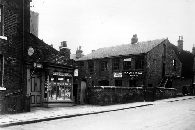 Skilbeck Street in May 1959. On the left is E. Tiler's hairdresser. On the right is a large industrial building, which is the premises of two firms - T.P. Whiteland and Sons Ltd, bakers engineers and sheet metal workers and  F. Hirst and Co, bakery engineers.