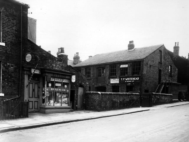Skilbeck Street in May 1959. On the left is E. Tiler's hairdresser. On the right is a large industrial building, which is the premises of two firms - T.P. Whiteland and Sons Ltd, bakers engineers and sheet metal workers and  F. Hirst and Co, bakery engineers.