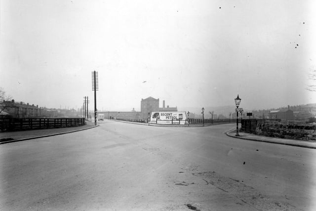 Whitehall Road in April 1950. In the background there are industrial premises and a sign advertising Regent petrol. Street lamps, road signs and telegraph poles line the roads.