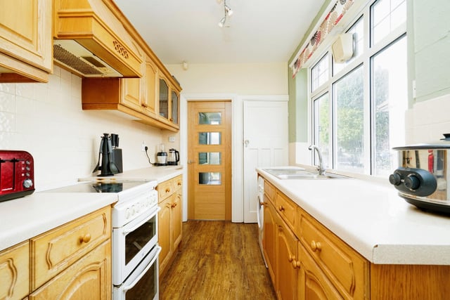 A kitchen fitted with a range of units is beautifully decorated with wooden cabinets.