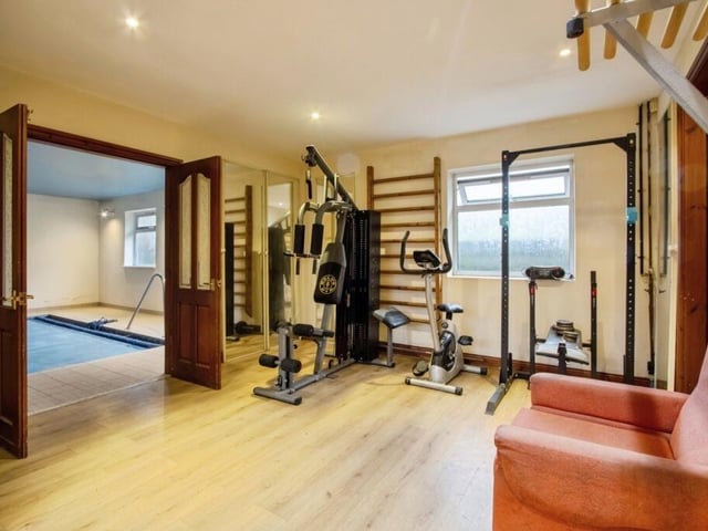 The gym area is linked to the swimming pool through double doors.