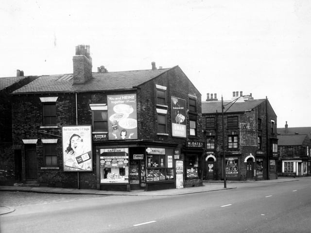 L. Mustill's greengrocers on Wellington Street is followed to the right by a fish and rabbit shop in May 1959. The entrance to Nicholson Street follows, then Angus Bros, cycle dealers. Renison Street can be seen on the left edge of this view.