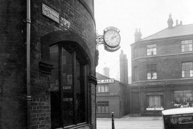 The junction of South Brook Street with Hunslet Lane in January 1935. The clock of Simms Motor Units Ltd., Magneto manufacturer, is on the corner with their delivery van parked outside. Opposite on Hunslet Lane, the 'Ales' sign from the Scarbro' Castle is visible next to the entrance to Whitechapel Yard. To the right the first property is apartments owned by Mrs. Alice Ann Sidebottom.