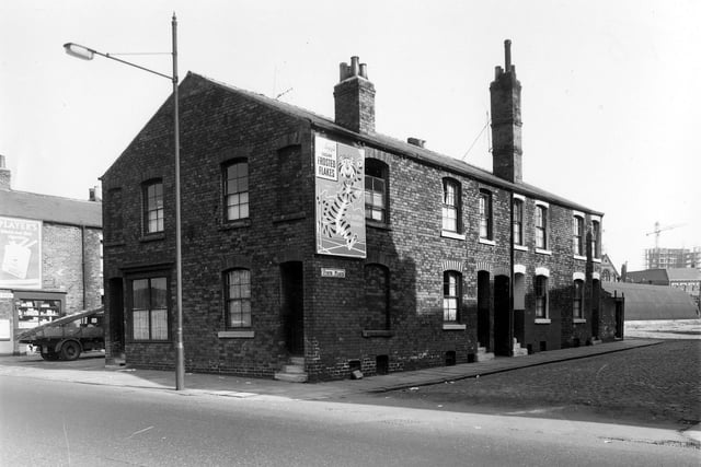 On the far left of the image is Firth Street. In the gable end of the block of terraced houses are numbers 36 and 38 Cross Stamford Street. On the side wall of number 38 is an advertisement for Kellogg's sugar frosted flakes. On the right of the image are numbers 1 to 5 Firth Place, a row of three back-to-back terraced houses with a ginnel between numbers 1 and 3 allowing access to Firth Street. On the right of number 3 is a row of shared outside toilets. This area was locally known as Newtown. Pictured in September 1959.