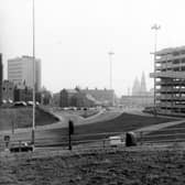 The Leeds Inner Ring Road as it joins Woodhouse Lane. Visible in the distance are the clock tower of the Town Hall and one of the gilded owl topped twin pinnacles of the Civic Hall. On the right is the Woodhouse Lane car park, opened August 6, 1970 with 1,100 spaces.