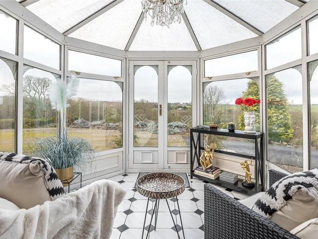 A conservatory extension acts as the property's formal entrance, leading to a grand landing hall.