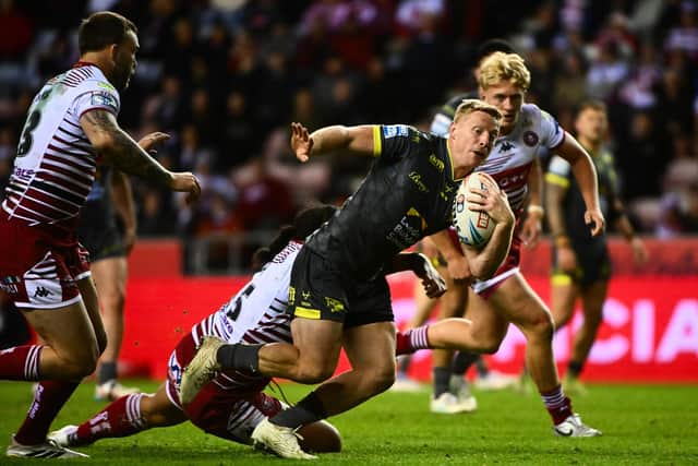 Leeds Rhinos full-back Lachie Miller is tackled by Patrick Mago during Wigan Warriors' home win in May. Picture by Olly Hassell/SWpix.com.
