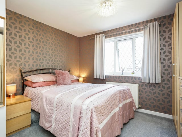 Upstairs, the master bedroom is to the left, overlooking the rear garden and containing an en-suite with a rainfall shower.