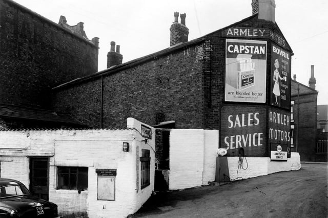 The Armley Motors garage located by the gable end ofStanningley Road in March 1958. Offered in the sales service are products by Esso, Michelin and Dunlop. An air machine stands on the right while mounted on the garage wall on the left is a Michelin motoring map and sign reading 'All vehicles garaged and driven at owners risk'
