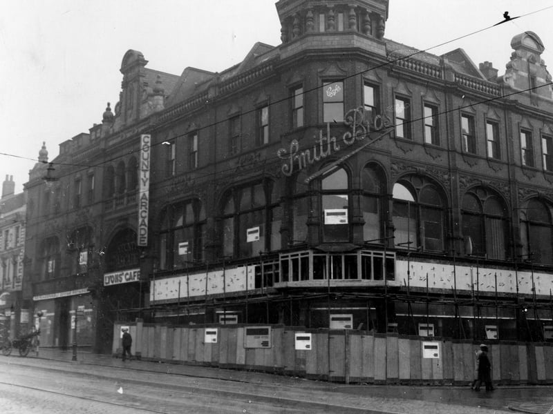 improvement works to  Smith Brothers in The County Arcade in  September 1937. The illuminating 'Smith Brothers' sign is visible on the corner of the building where Queen Victoria Street starts. There is a cart with ladders parked by the road side.
