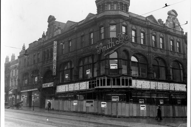 improvement works to  Smith Brothers in The County Arcade in  September 1937. The illuminating 'Smith Brothers' sign is visible on the corner of the building where Queen Victoria Street starts. There is a cart with ladders parked by the road side.